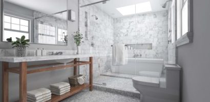 Bright natural light in a gorgeous bathroom with glass enclosure and marble tile.